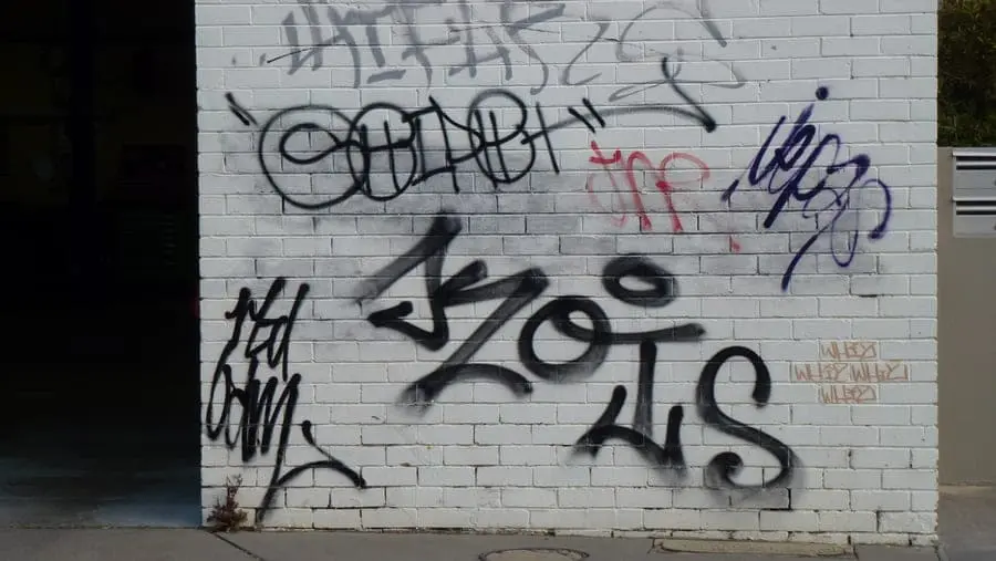 Graffiti on a white-painted brick wall.