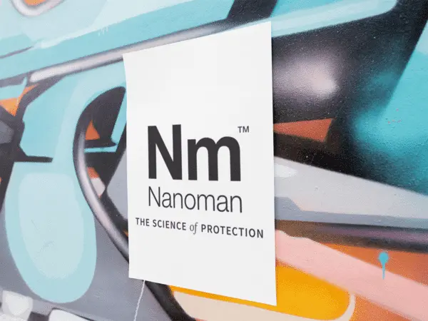 A Nanoman sign in front of a mural.