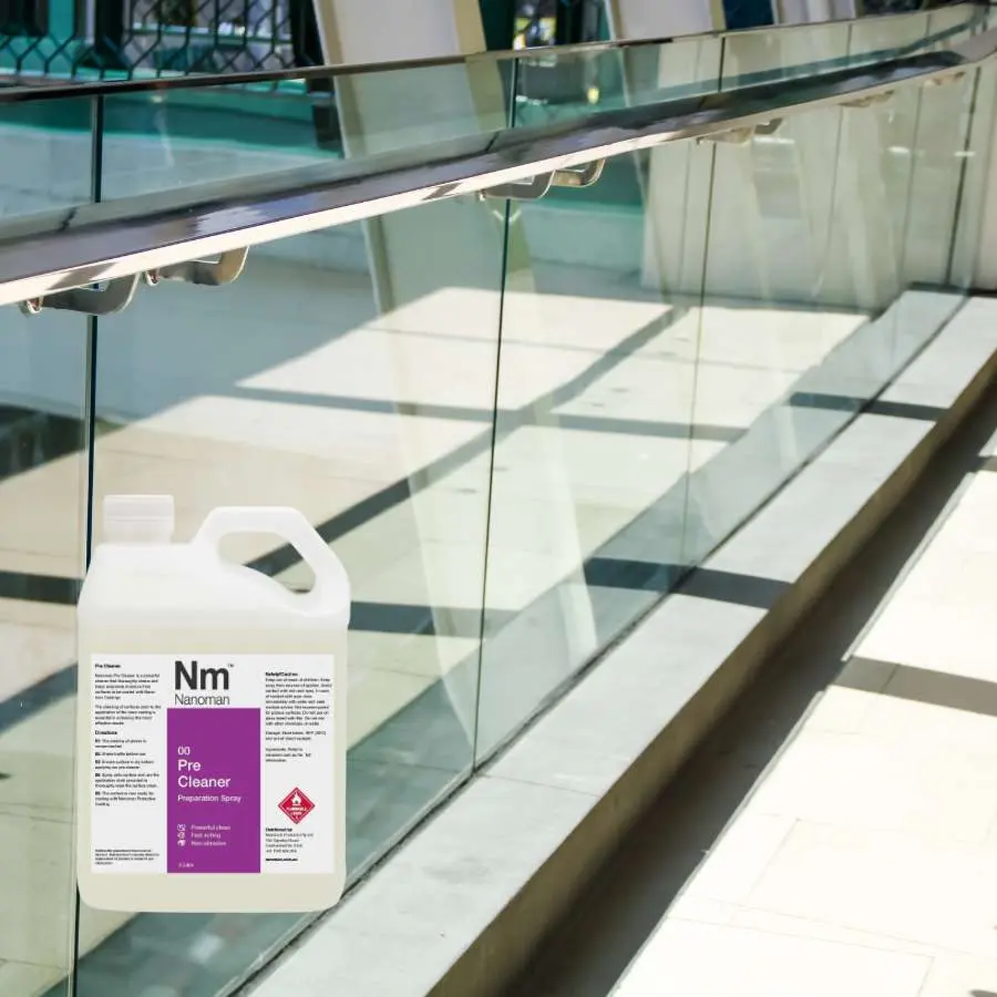 Pre Cleaner spray bottle and can by a glass balcony railing